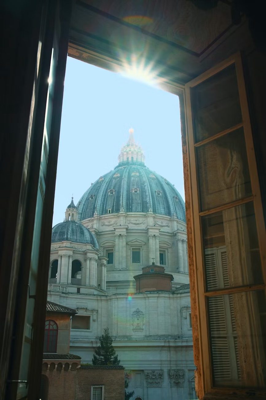 Offenes Fenster mit Blick auf die Kuppel des Petersdoms in Rom